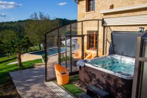 a glass house with a hot tub in the yard at Aux Bories de Marquay, chambres d'hôtes B&B avec piscine et SPA près de Sarlat in Marquay