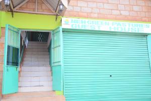 un edificio con una puerta de garaje azul y un hostal en New Green Pastures Guest House, en Eldoret