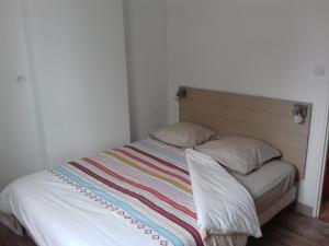 un letto con una coperta a righe e due cuscini di appartement Carpentier a Berck-sur-Mer