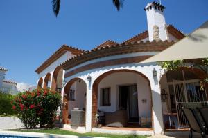 ein Haus mit einem Torbogen und einem Pool in der Unterkunft DAMA Villa con piscina privada in Miami Platja