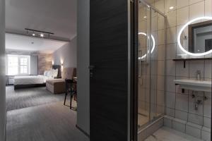 uma casa de banho com um lavatório e um quarto com uma cama em Sherwood Hotel em Rostov on Don