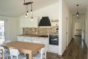 a kitchen with a wooden table and white cabinets at Da zia Giò in Padula