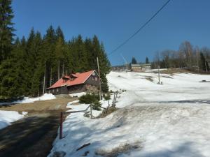 een huis met een rood dak in de sneeuw bij Roubenka u vleku in Josefuv dul