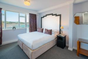 a bedroom with a large bed and a window at Burgh Island Hotel in Bigbury on Sea