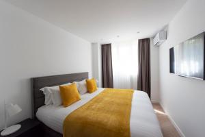 巴黎的住宿－Opera，酒店客房配有一张带黄色枕头的大床