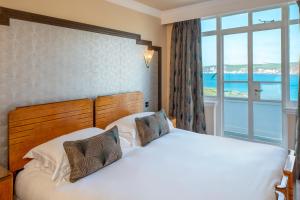 a bedroom with a bed and a large window at Burgh Island Hotel in Bigbury on Sea