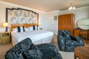 a hotel room with a bed and two chairs at Burgh Island Hotel in Bigbury on Sea