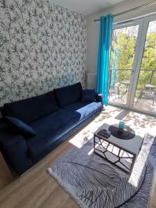 a living room with a blue couch and a table at Apartament NaGrobli in Wrocław