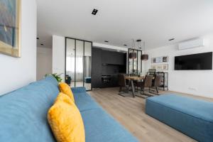 a living room with a blue couch and a dining room at Atelier in Paris