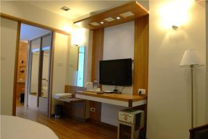 ein Schlafzimmer mit einem Schreibtisch und einem TV darauf in der Unterkunft Beautiful Hotel In Lonavala in Lonavla