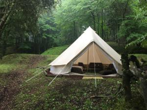 uma tenda branca no meio de uma floresta em ACAMPALE - Glamping La Garrotxa - Santa Pau em Santa Pau