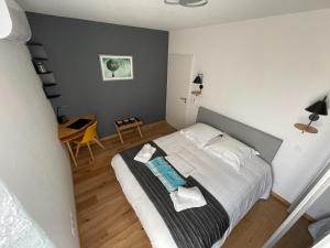 een slaapkamer met een bed en een tafel. bij T3 BLUE NOTE -4 étoiles- BALARUC-LES-BAINS in Balaruc-les-Bains