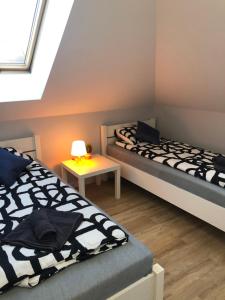 sypialnia z dwoma łóżkami i stołem z lampą w obiekcie Klimatyzowane Apartamenty i Pokoje przy Targach Kielce w Kielcach