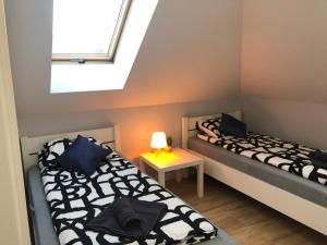 dwa łóżka w małym pokoju z oknem w obiekcie Klimatyzowane Apartamenty i Pokoje przy Targach Kielce w Kielcach