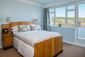 a bedroom with a bed and a large window at Burgh Island Hotel in Bigbury on Sea