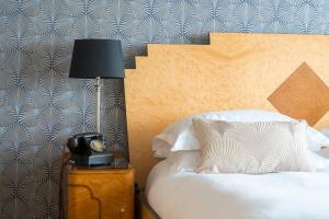 a bedroom with a bed with a lamp and a telephone at Burgh Island Hotel in Bigbury on Sea