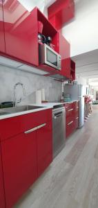 a red kitchen with a sink and a microwave at Pearl of Adriatic in Dubrovnik