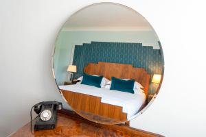 a bedroom with a bed in a round mirror at Burgh Island Hotel in Bigbury on Sea