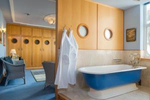 a bathroom with a blue tub in a room at Burgh Island Hotel in Bigbury on Sea