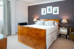 a bedroom with a large bed with a wooden headboard at Burgh Island Hotel in Bigbury on Sea