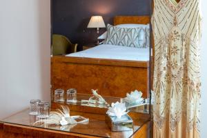a mirror in a bedroom with a bed and a table at Burgh Island Hotel in Bigbury on Sea