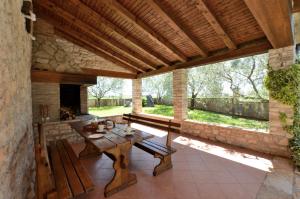 an outdoor patio with a table and a fireplace at House Mariano in Baldaši