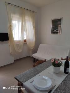 een woonkamer met een tafel en een bed bij Residence Carabella in Vieste