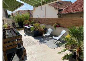 een patio met stoelen, een tafel en een hek bij B&B - Chambres d'hôtes Le Foch in Avignon