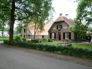 a house with a landscaping in front of it at De Rozephoeve in Oisterwijk