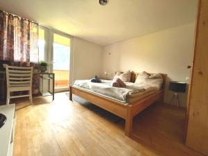 a bedroom with a bed and a large window at Rosa - Huusa im Bregenzerwald in Au im Bregenzerwald