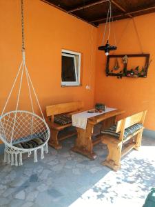 a room with a swing and a table and benches at Studio apartman Krosna in Perušić