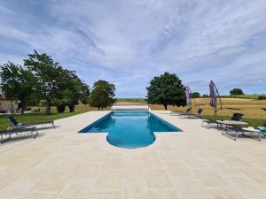 a swimming pool with two chairs and a table at Le Shedeaux in Saint-Privat-des-Prés