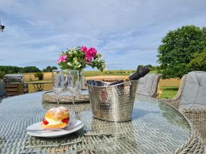 una mesa con un sándwich y un jarrón de flores en Le Shedeaux en Saint-Privat-des-Prés