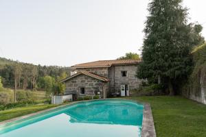 una gran piscina frente a una casa de piedra en Quinta de Pindela - Natureza e Tradicao, en Vila Nova de Famalicão