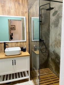 uma casa de banho com um chuveiro e um lavatório. em Villa Rosa Boutique em Almancil