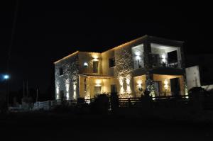 un edificio con luces encendidas por la noche en Liri's Apartments, en Kalamaki