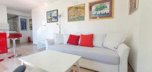 a living room with a white couch with red pillows at Pearl of Adriatic in Dubrovnik