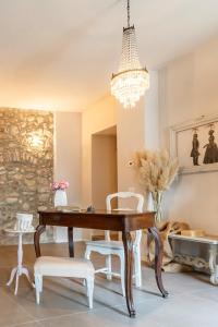 una sala da pranzo con tavolo, sedie e lampadario pendente di Il cantuccio sul Garda - Relais di charme a Cavaion Veronese