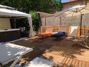 a wooden deck with chairs and an umbrella at Hotel Villa Serena in Castrocaro Terme