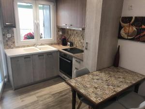 małą kuchnię ze stołem i zlewem w obiekcie Voula's Cozy Studio in Ano Mera Mykonos w mieście Ano Mera +13 zdjęć