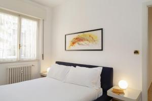 una camera con un letto bianco e una finestra di Una Casa al Mare nel cuore di Rapallo by Wonderful Italy a Rapallo