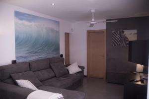 a living room with a couch and a television at Fonoll Mari in S'Illot