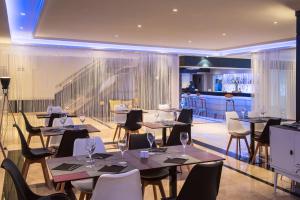 un ristorante con tavoli e sedie e un bar di Hotel Madrid Alameda Aeropuerto, Affiliated by Meliá a Madrid