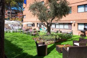 a courtyard with tables and chairs and a tree at Hotel Madrid Alameda Aeropuerto, Affiliated by Meliá in Madrid