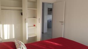 a bedroom with a red bed and a closet at Apartment Janja in Medulin