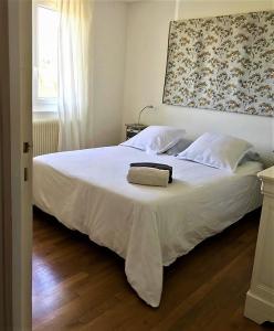 a bedroom with a white bed with a towel on it at ENTRE TERRE ET MER in Blonville-sur-Mer