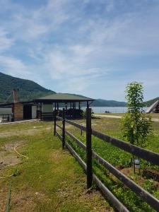 a fence in front of a building next to the water at Pensiunea Lorena in Cozla