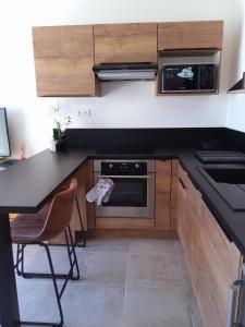 een keuken met een zwart aanrecht en houten kasten bij Romytt Suite in Saint-Quentin-la-Poterie
