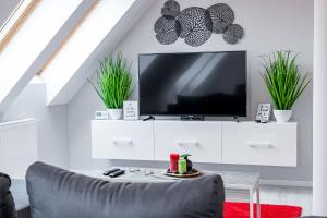 una sala de estar con TV en un armario blanco en Grey Suites Pécs, en Pécs