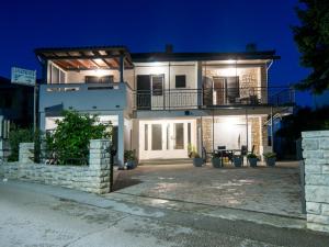 ein großes weißes Haus mit Balkon in der Nacht in der Unterkunft Apartments Jasna 3 in Novigrad Istria